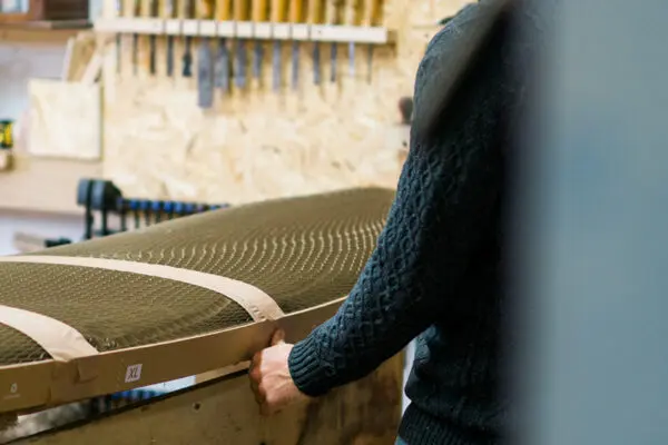 Otter surfboards founder James Otter placing on a protective sustainable Flexi-Hex surfboard packaging onto a wooden surfboard