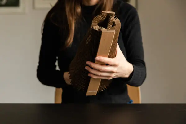 Image of a female holding a Flexi-Hex protective, plastic-free, recyclable, biodegradable and compostable honeycomb Mini sleeve