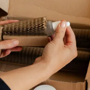 A woman placing a beauty product by Mellow Noir being placed inside a Flexi-Hex protective paper sleeve