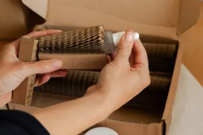 A woman placing a beauty product by Mellow Noir being placed inside a Flexi-Hex protective paper sleeve