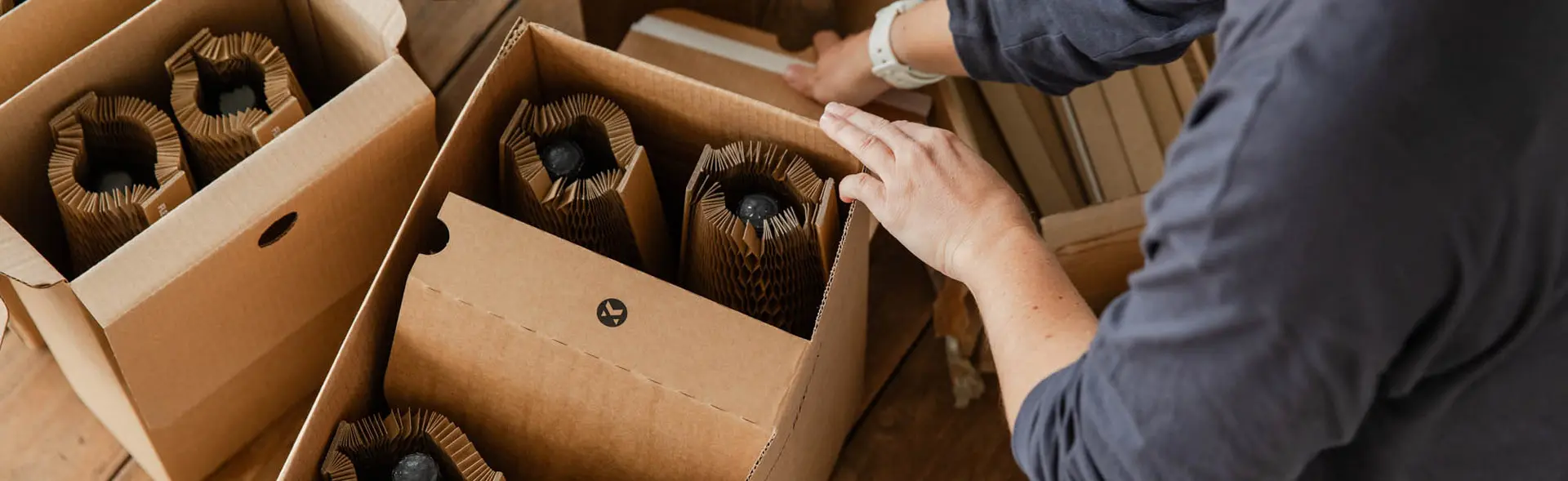 Flexi-Hex boxes and protective honeycomb sleeves being used to package bottles for mail order
