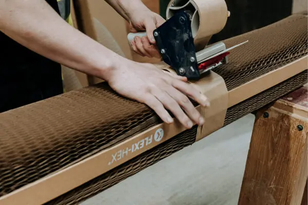 Flexi-Hex protective paper plastic free packaging being taped together with brown tape in a warehouse