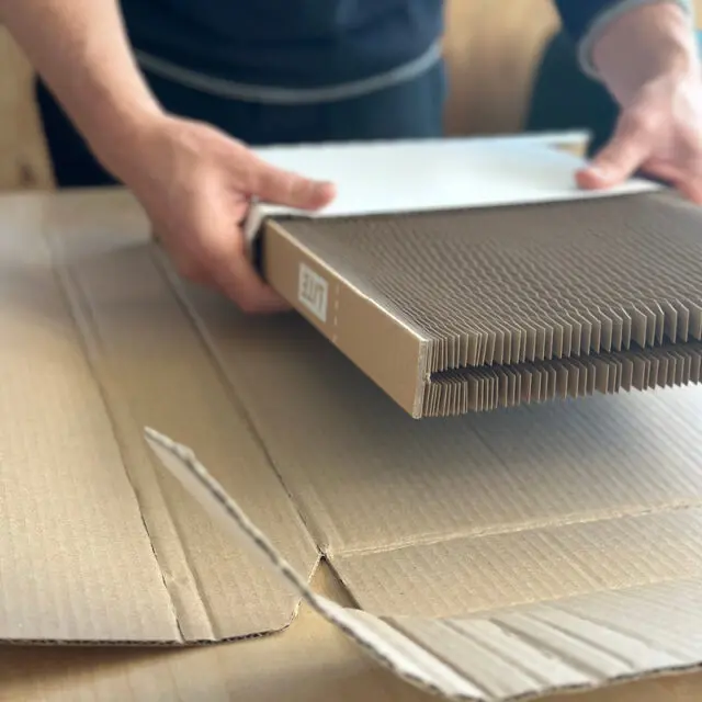 A man demonstrating how to use Flexi-Hex packaging using a plastic free Lite sleeve to protect frames