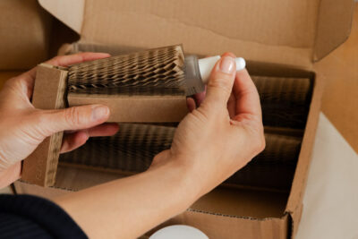 A woman placing a beauty product by Mellow Noir being placed inside a Flexi-Hex protective paper sleeve