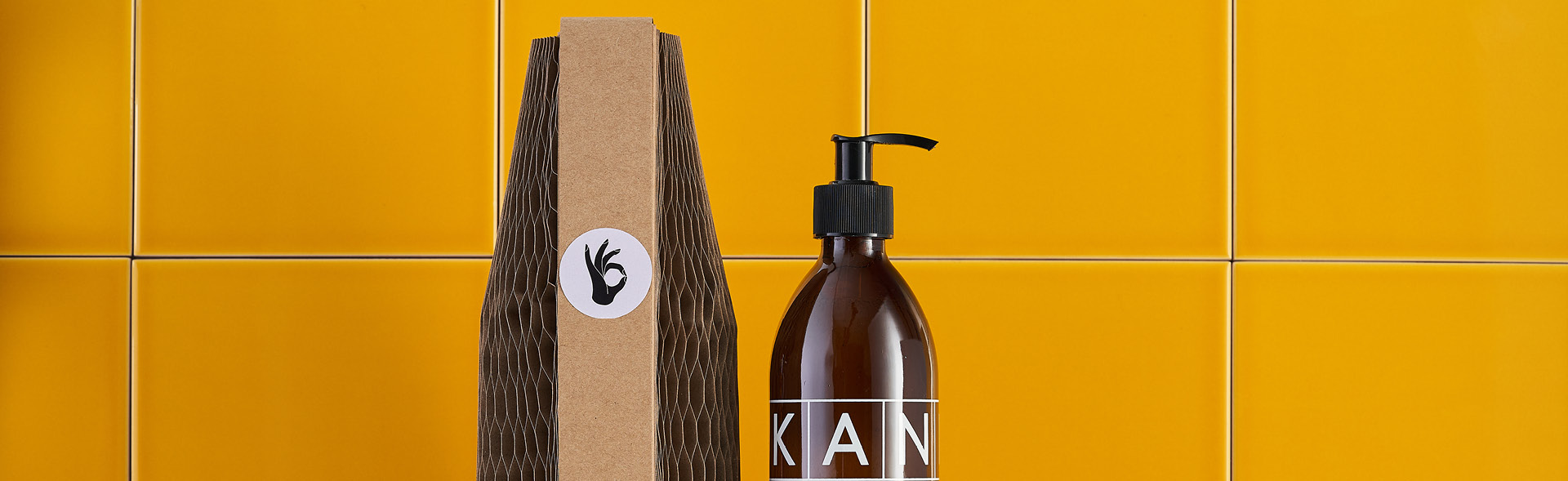 A Flexi-Hex mini sleeve on Kan Kan beauty products against a yellow tiled backdrop
