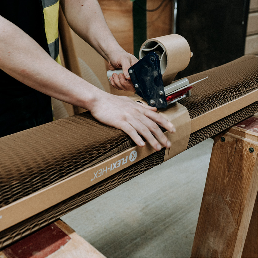 Flexi-Hex protective paper plastic free packaging being taped together with brown tape in a warehouse